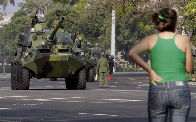 A woman watches Cuban soldiers rehearse for an upcoming parade to commemorate the 50th anniversary of the Bay of Pigs at the Plaza de la Revolution in Havana, Cuba, Thursday April 14, 2011.  The parade commemorating the anniversary of the failed 1961 invasion by U.S.-backed Cuban exiles takes place Saturday. (AP Photo/Franklin Reyes)